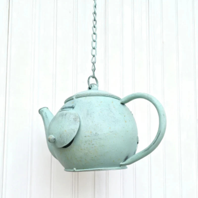 Light blue teapot-shaped hanging planter on a white background
