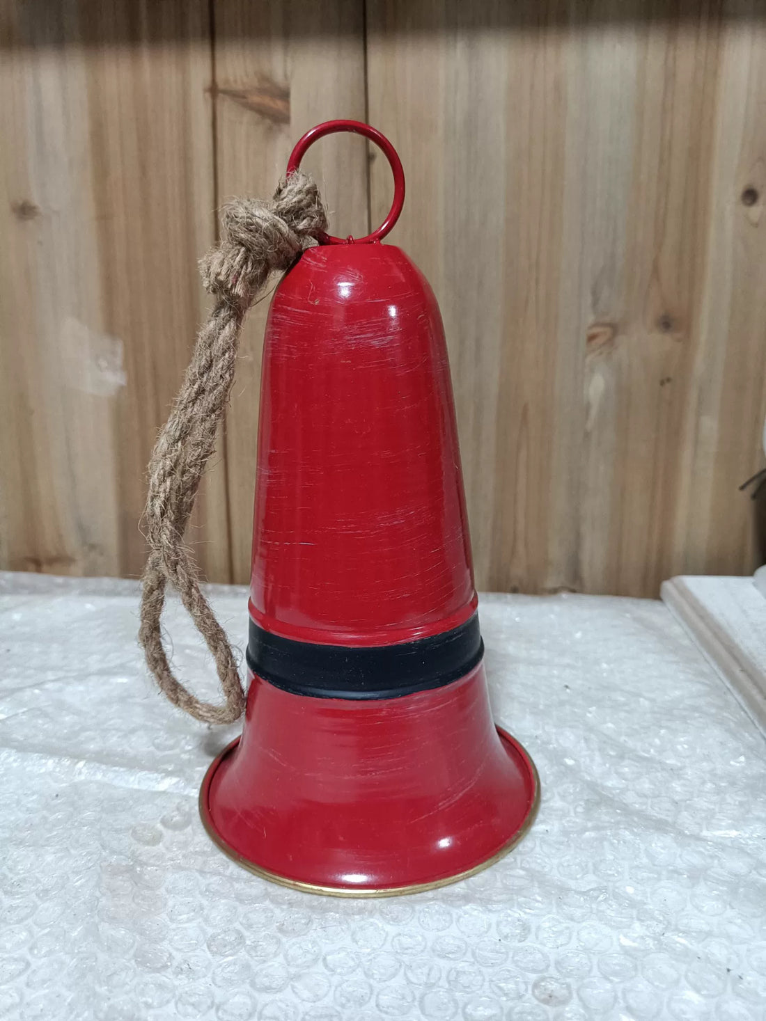 Red metal Santa bell decoration with jute rope loop and pedestal base.