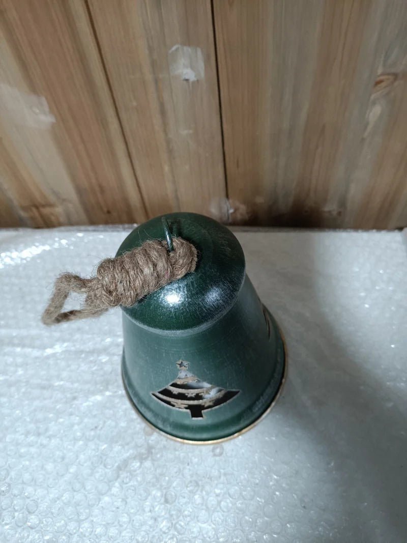 Green metal Christmas tree bell ornament with jute rope and cut-out tree emblem, top view