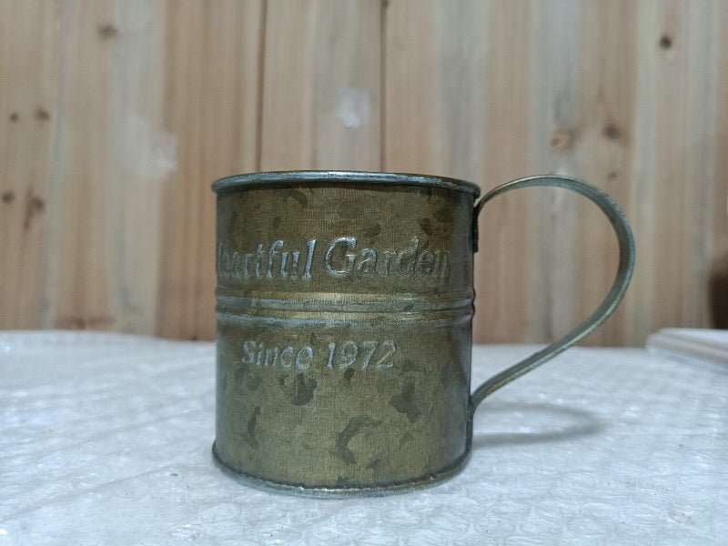 Rustic metal teacup planter with handle, 'Heartful Garden' and 'Since 1927' text, patina