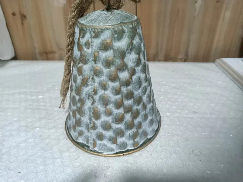 Decorative bell with textured surface on a light background