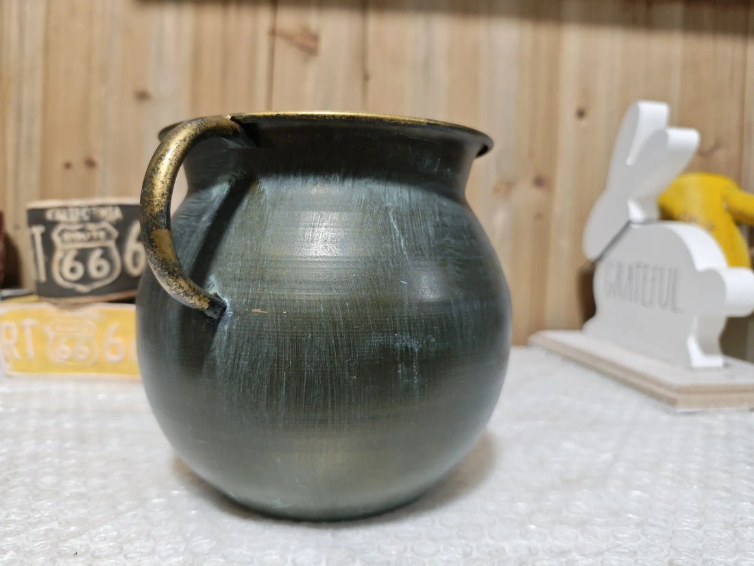 Rustic bronze metal planter pot with two handles and flared rim, standing view