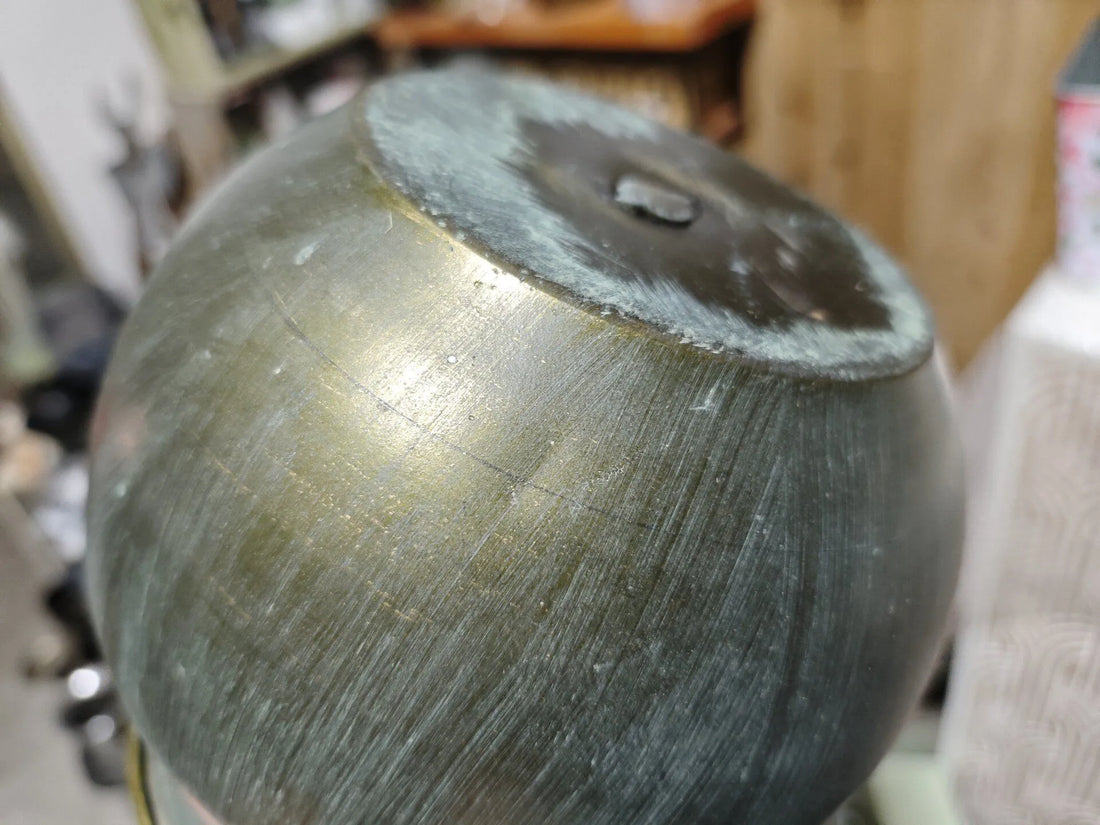 Close-up of rustic metal planter pot lid-style rim with handle loop