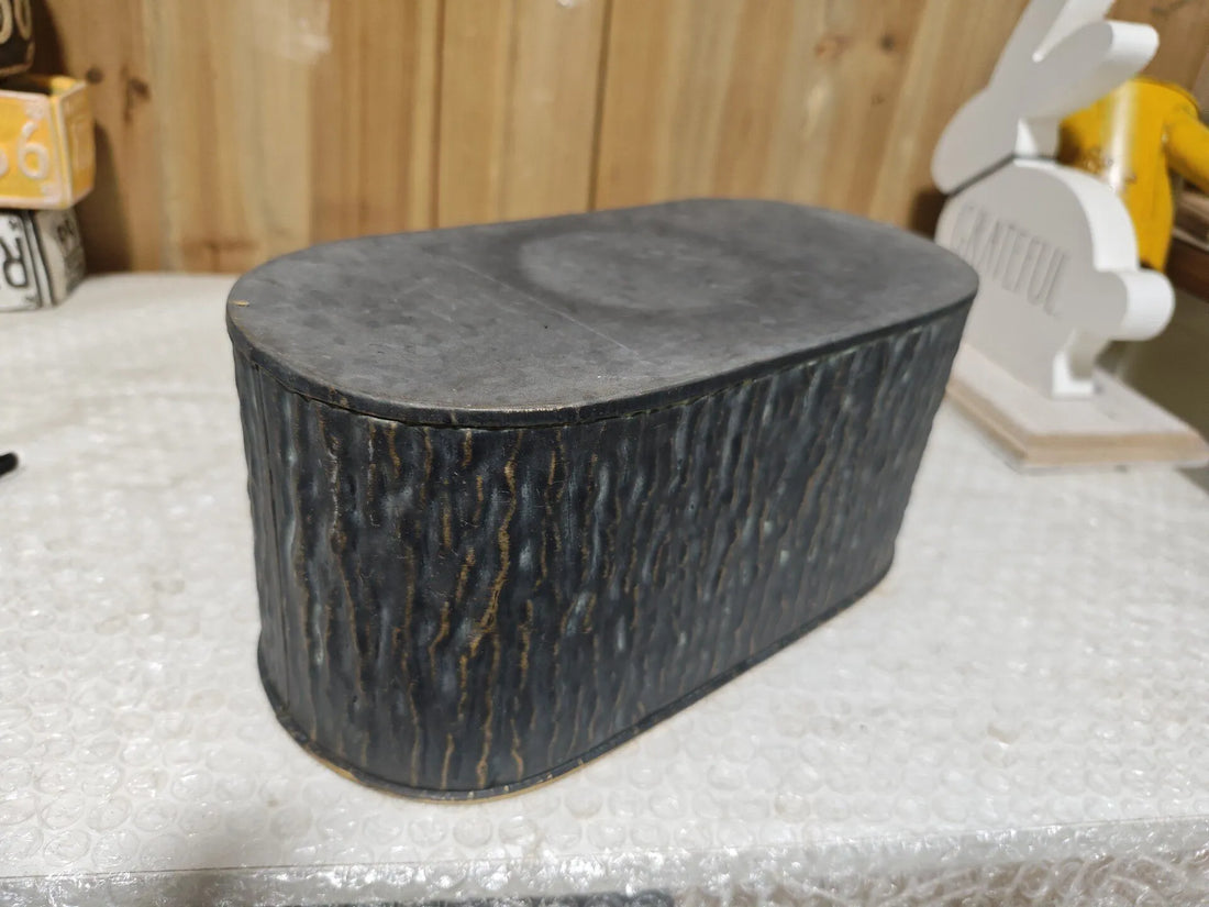 Dark faux-bark metal planter with flat top and gold-trim rim