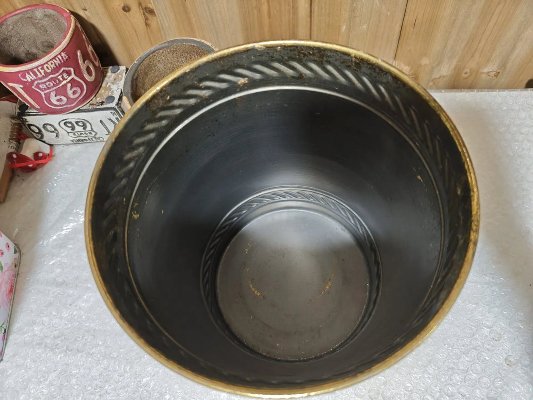 Antique gold distressed metal planter with dark interior and embossed circular base