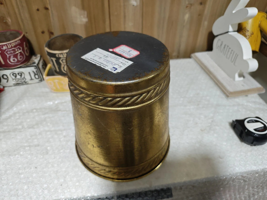 Antique gold distressed metal planter with rounded lid-like top and embossed side banding