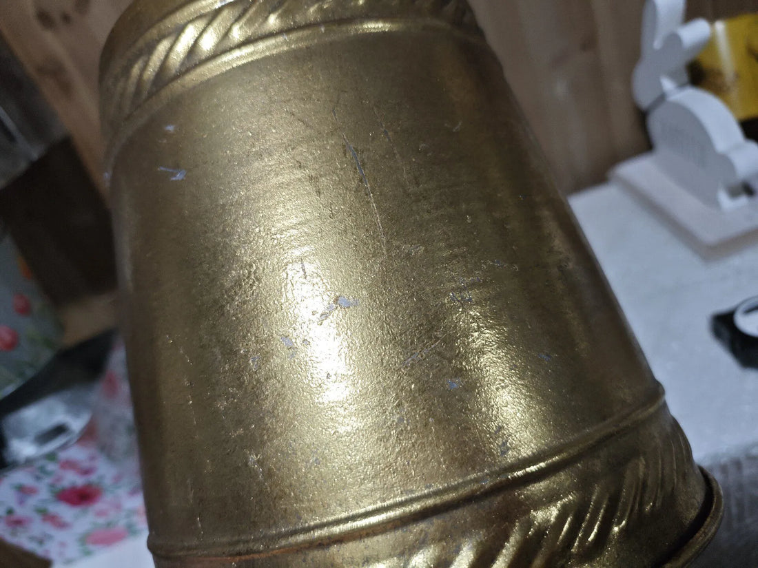 Antique gold distressed metal planter close-up with embossed ring detail near base