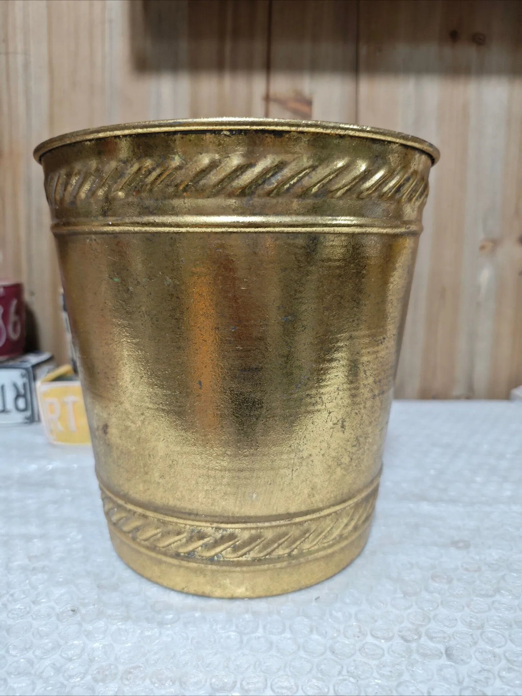 Antique gold distressed metal planter with embossed zigzag trim around upper edge