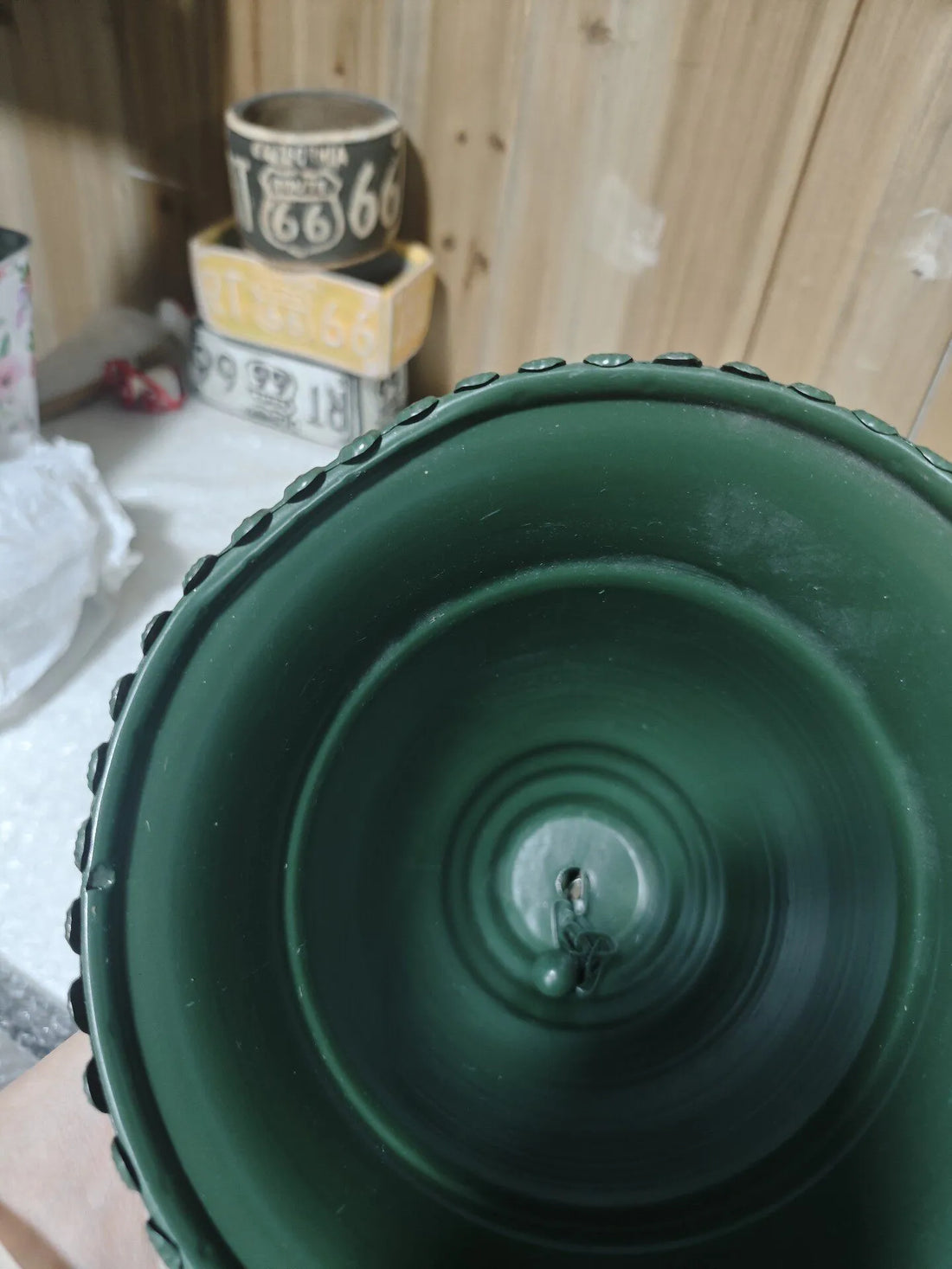 Green iron hanging bell top view with beaded edge and central cap