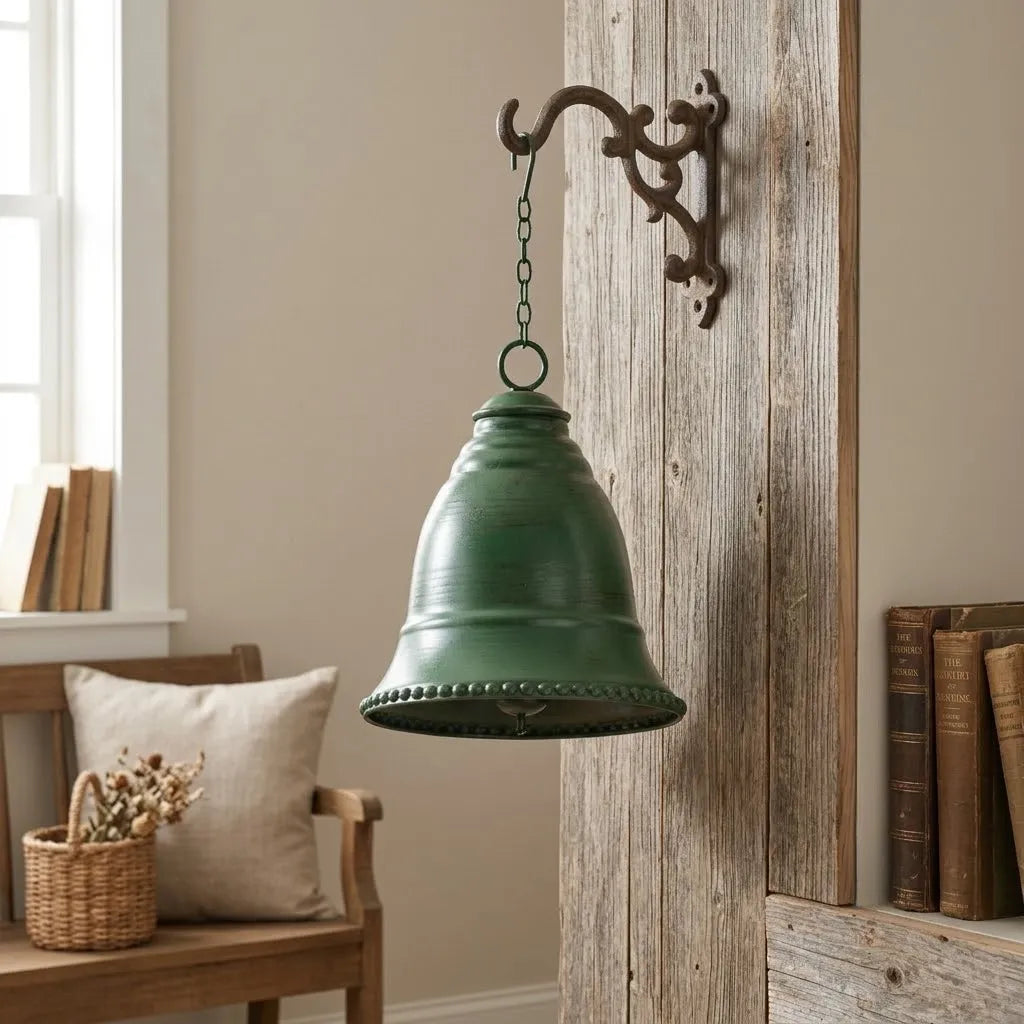 Green iron hanging bell with chain loop and domed shape against wood wall