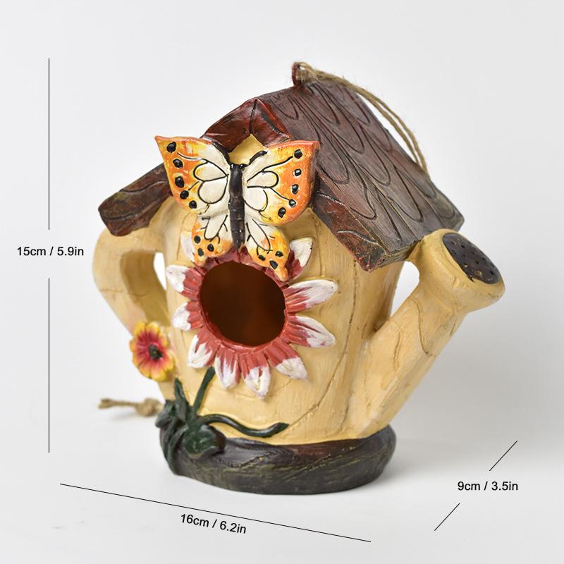 Hand-painted hanging birdhouse ornament with cream body, dark roof, butterfly, and flower accents