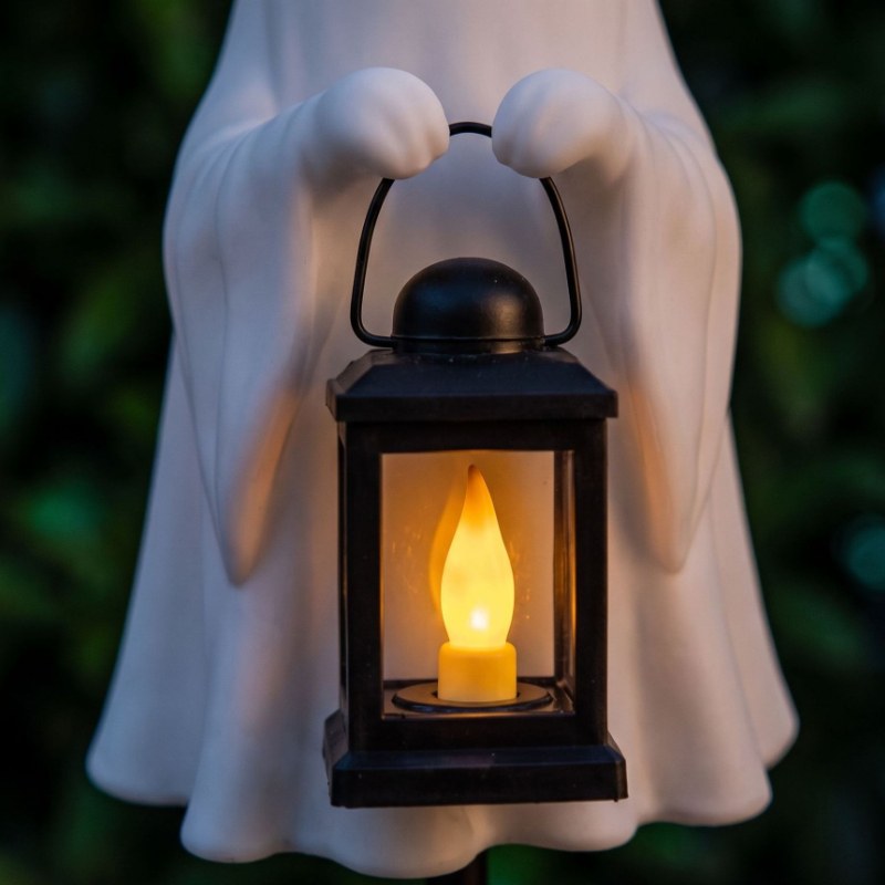 Spökfigur i harts med svart lykta och varmt stearinljus, solstångsstil