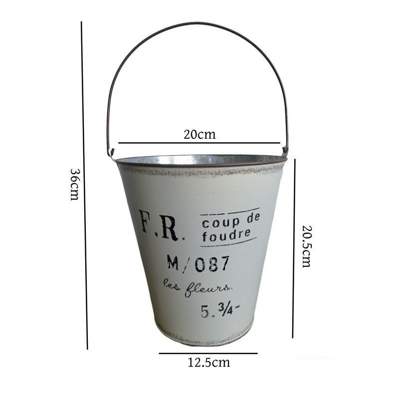 Grå vintage metalspandplantekasse med buet håndtag og teksten F.R. M/087