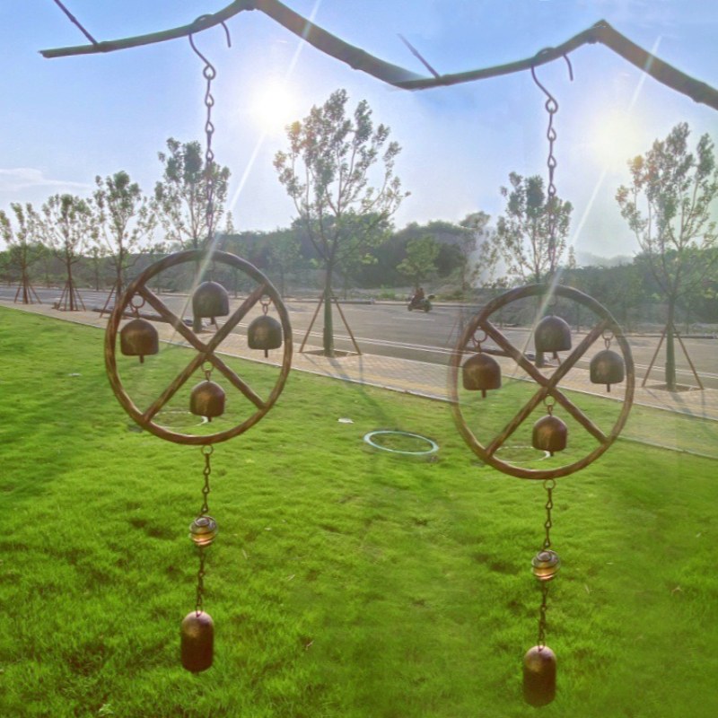 Campana de viento geométrica de bronce antiguo con marco de rueda redonda y campanillas colgantes.