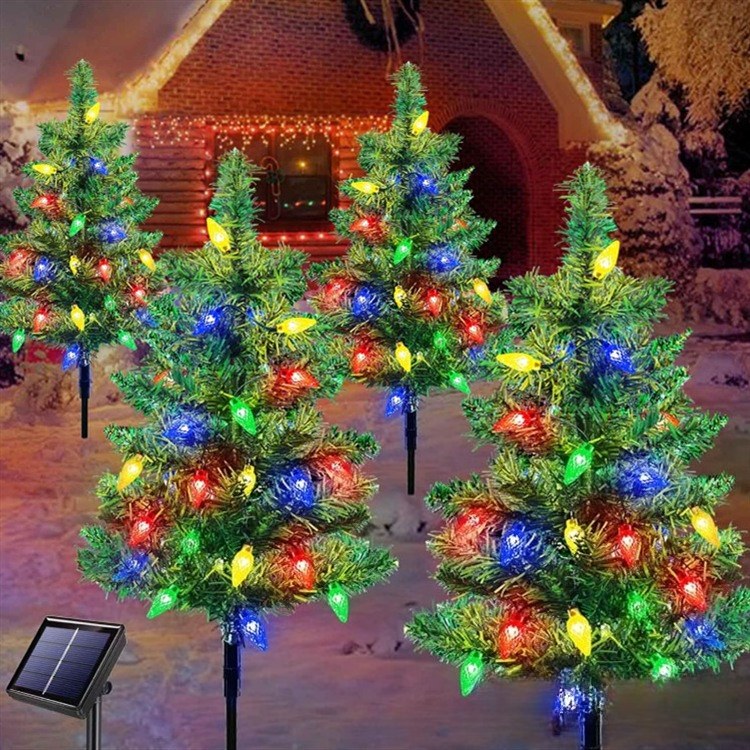 Four pre-lit solar Christmas tree stakes with multicolor LED lights and ground spikes