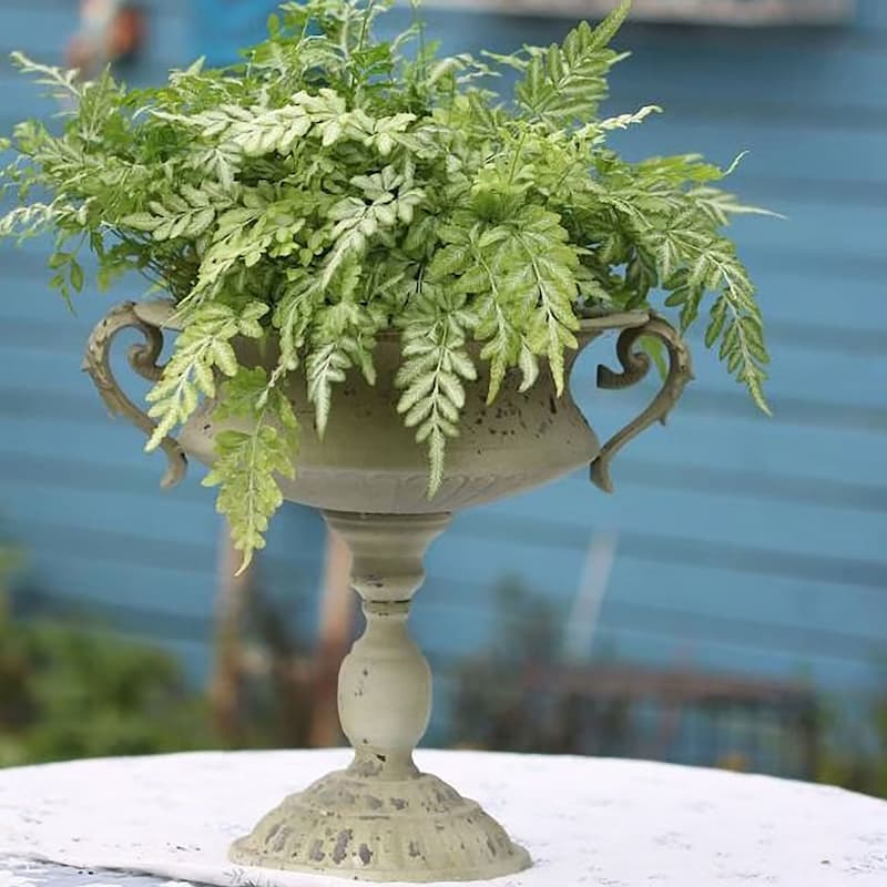 Distressed green pedestal planter urn with ornate side handles and fluted base