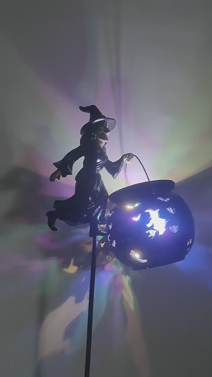 Video demonstrating a Halloween witch garden stake light holding a glowing cauldron with colorful LED projections