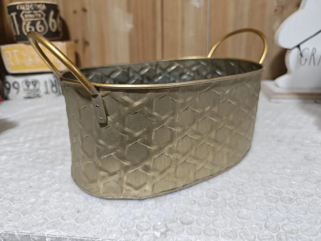 Gold-toned metal storage bowl with raised diamond embossed pattern and carry handle