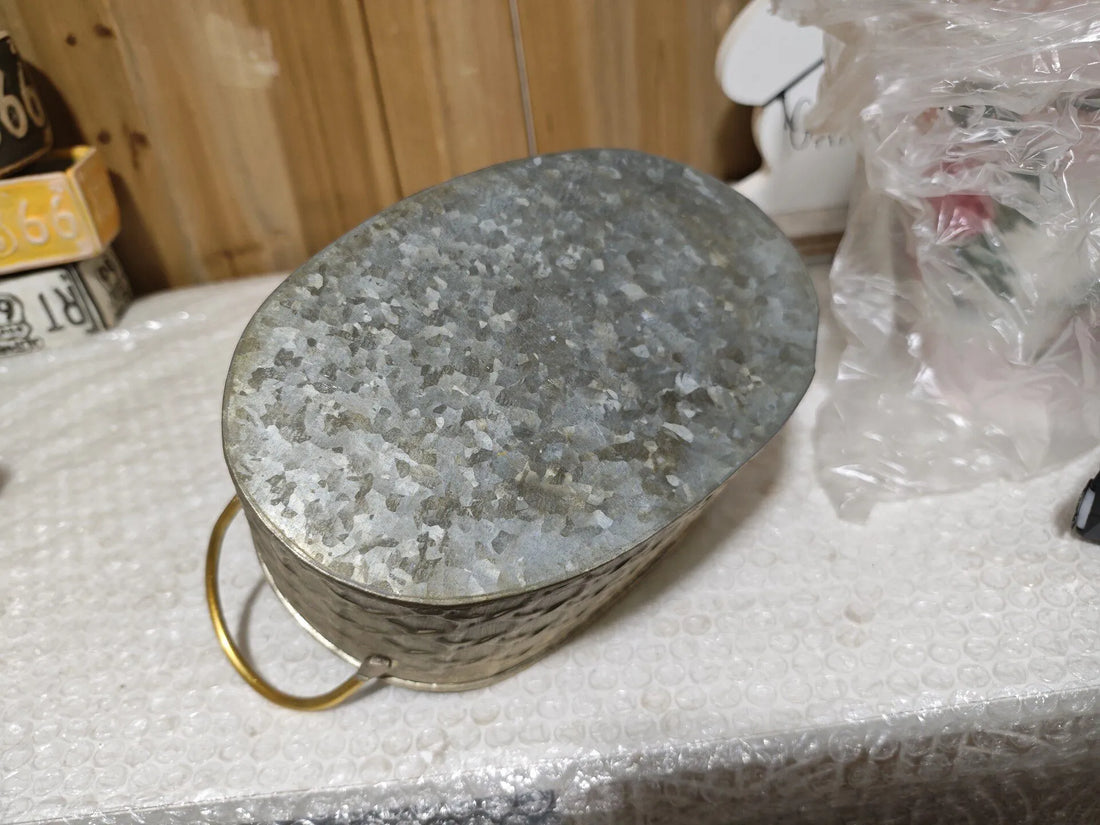 Oval metal planter tub with gold-toned rim, distressed gray speckled interior