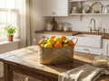 Gold-toned metal planter tub filled with oranges on a wooden kitchen counter