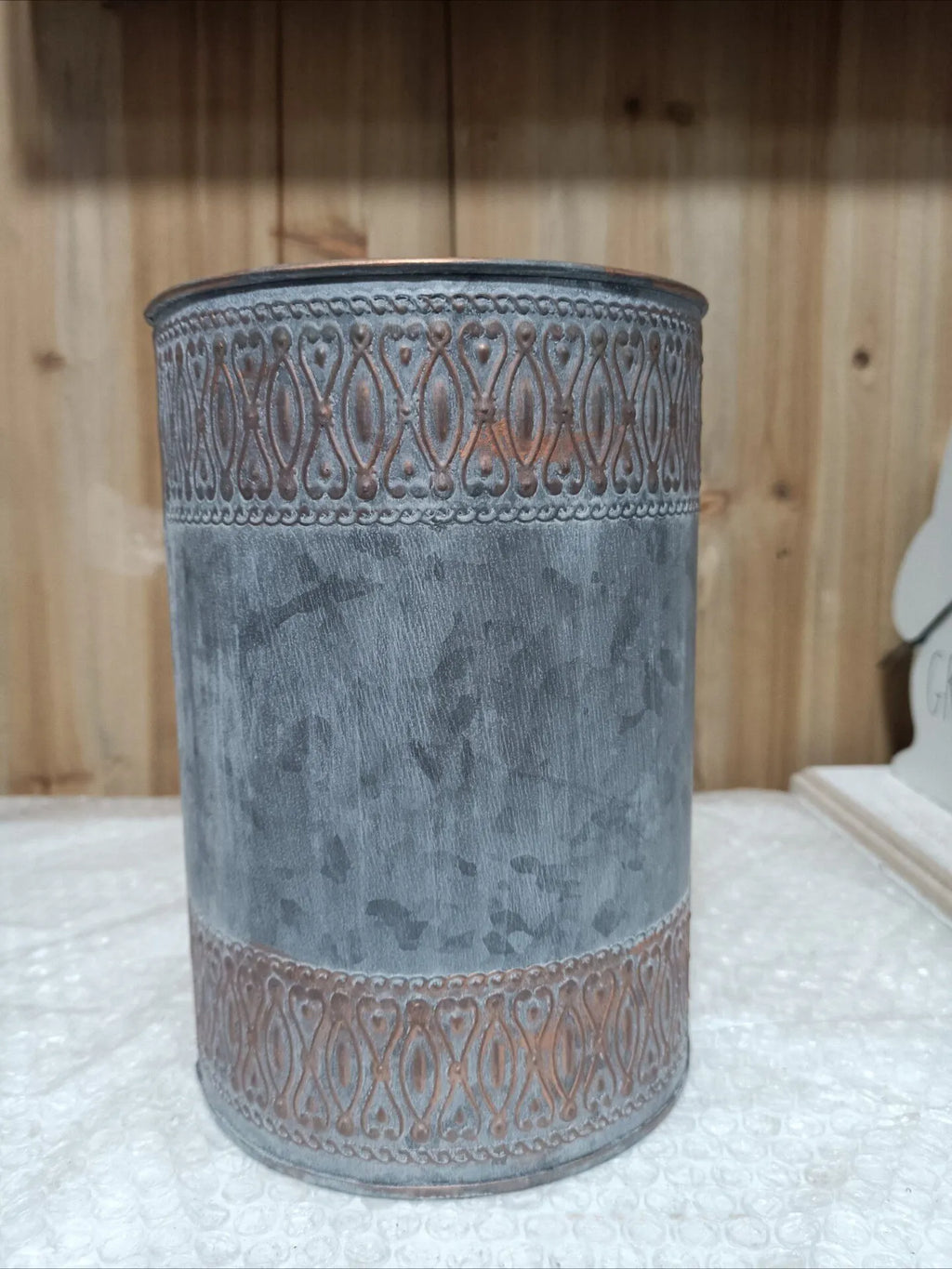 Gray embossed metal storage bucket with lid, cylindrical shape and decorative trim bands